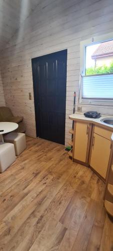 a room with a black door and a wooden floor at u Anny Pionierów 8B in Mielno