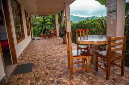 a room with a table and chairs on a patio at La Casa de Cecilia Mindo in Mindo