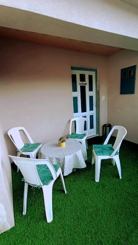 a patio with a table and chairs on the grass at Apartman Orhan in Mostar