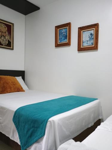 - une chambre avec 2 lits et 2 photos sur le mur dans l'établissement construcciones Guaduales del café, à Montenegro