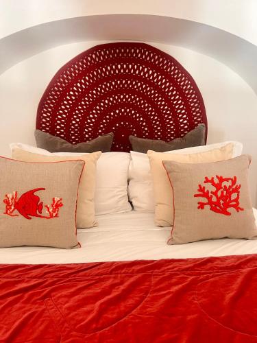 a bed with a red head board with pillows at Suite Belvedere Capri Exclusive Rooms in Capri