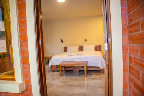 a bedroom with a bed and a table in a room at La Casa de Cecilia Mindo in Mindo