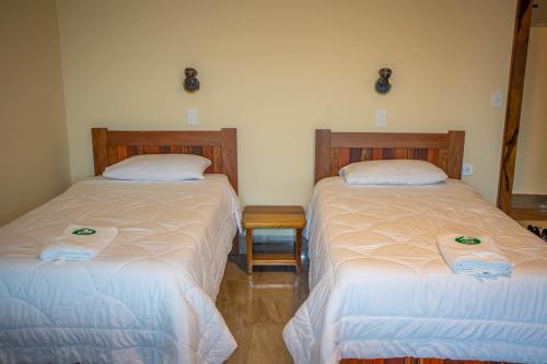 two beds sitting next to each other in a room at La Casa de Cecilia Mindo in Mindo