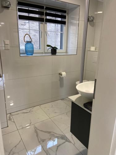 a white bathroom with a sink and a window at Ferienwohnung Traumpfad in Trimbs