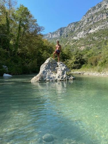 a man standing on a rock in the middle of a river at Chambre campagnarde in Roquestéron