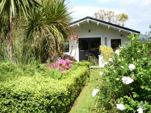 Una cabaña con flores y plantas en frente de ella. en Rodeen, en Castletownbere