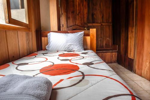 a bed with a flower design on it in a room at La Casa de Cecilia Mindo in Mindo