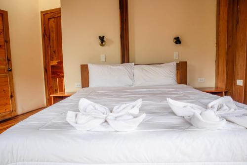 a white bed with white towels on it at La Casa de Cecilia Mindo in Mindo