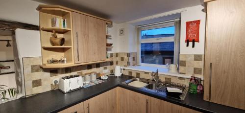 a kitchen with a sink and a window at Two bedroom character cottage in Rhuddlan