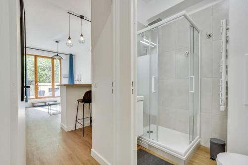 La salle de bains blanche est pourvue d'une douche en verre et d'une table. dans l'établissement Perfect for Work, à Clichy