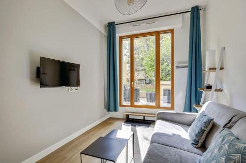 un salon avec un canapé et une fenêtre dans l'établissement Perfect for Work, à Clichy