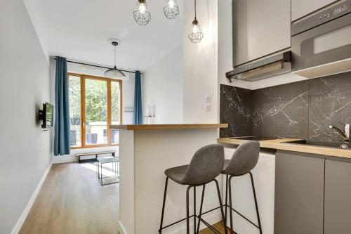 une cuisine avec deux tabourets au milieu d'un comptoir dans l'établissement Perfect for Work, à Clichy