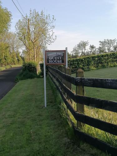 una señal para una casa de huéspedes junto a una valla en Valley View 2 NI Tourist board Registered, en Tamnyrankin