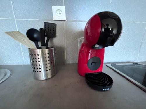 un mixeur rouge assis sur un comptoir à côté d'une tasse dans l'établissement Prado Plage, à Marseille