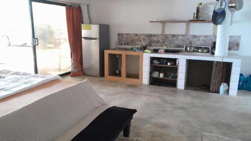 a room with a kitchen with a refrigerator and a table at Casa cangrejo in Garza