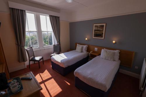Una cama o camas en una habitación de Manor Hotel