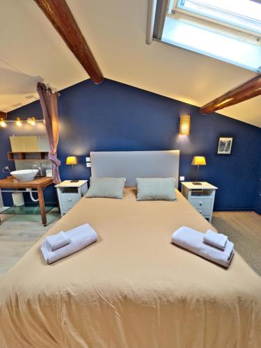 une chambre avec un grand lit avec deux serviettes dessus dans l'établissement Gîte classé 3* dans magnifique bastide provençale, à Auriol