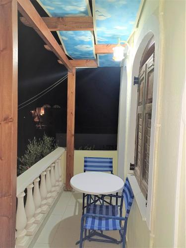 a table and chairs on a balcony with a window at Evelina Family Beach Pension a breath away from the Black Beach offer plenty of accommodation type to suit every traveler's needs-Economic Rooms-Thematic Rooms-Design Rooms-Kitchenette Rooms-Studios-Small Apartments in Perissa