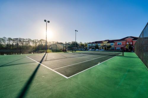 a tennis court with a net and a tennis at Beautiful Townhome just 8 miles from Disney in Kissimmee
