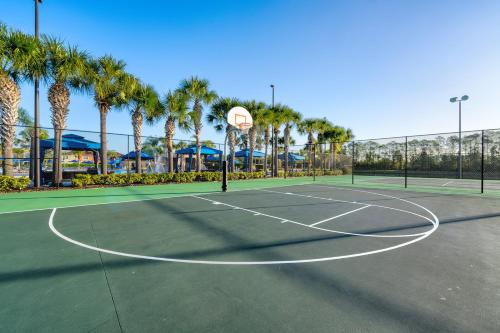 a tennis court with a basketball hoop and palm trees at Beautiful Townhome just 8 miles from Disney in Kissimmee