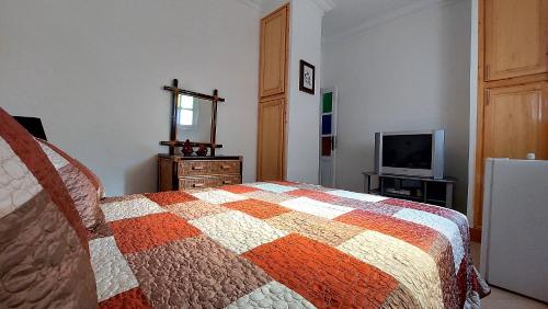 a bedroom with a bed and a television at Taddart, Maison de vacances in Temara