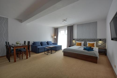 um quarto com uma cama, um sofá e uma mesa em Willa MAJA em Krynica-Zdrój