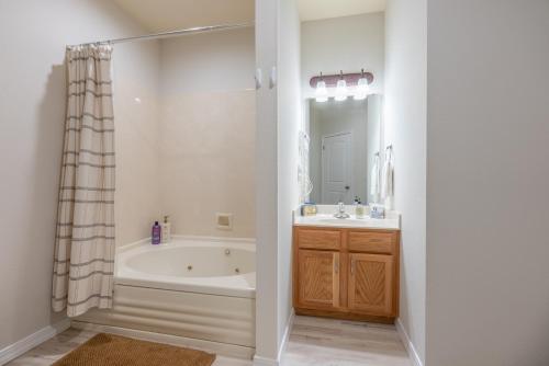 a bathroom with a tub and a sink and a mirror at Golf View - Elevator Accessible - Center Of Branson - FREE TICKETS INCLUDED - RL8-11A in Branson
