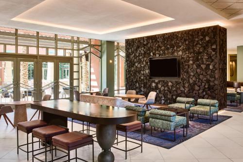 a lobby with a table and chairs and a tv at Renaissance Phoenix Glendale Hotel & Spa in Glendale