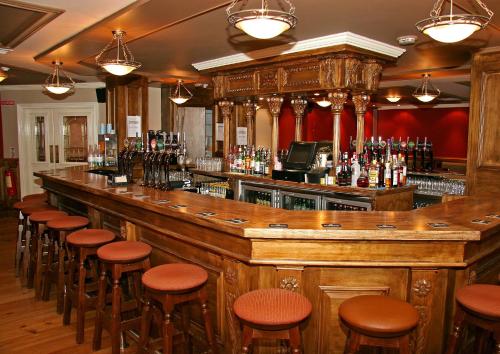 um bar com um monte de bancos num quarto em Harding Hotel em Dublin