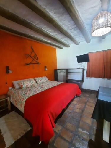 um quarto com uma cama vermelha num quarto em Posta Kamak Eco Posada Rural em Bella Vista