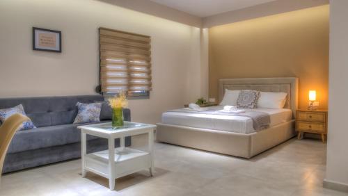 a living room with a bed and a couch at Loutsiana Apartments Corfu in Alykes Potamou