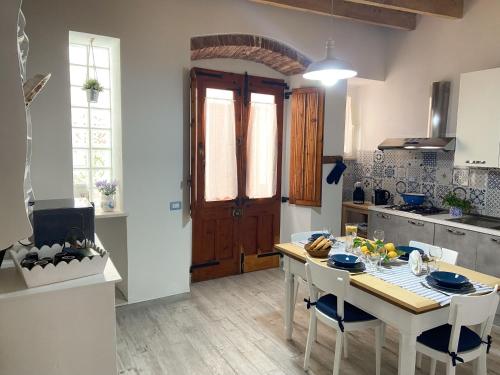 a kitchen with a table and some chairs and a table and a kitchen with at CaTó - Le vacanze come a casa tua in Carloforte