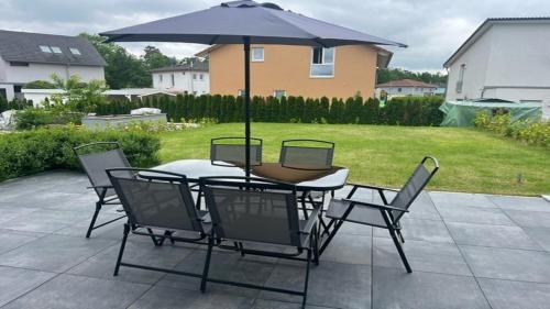 a table and chairs with an umbrella on a patio at Moderne Ferienwohnung Sonnenbühl in Singen