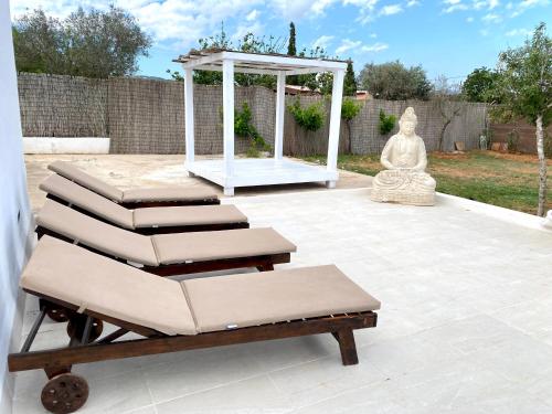 a group of lounge chairs and a gazebo on a patio at Villa Air - Relax, close to bossa beach, spacious rooms and private pool in Sant Jordi