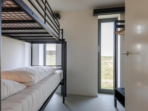 een slaapkamer met een stapelbed en een groot raam bij Cottage in Wissenkerke near Banjaard Beach in Wissenkerke