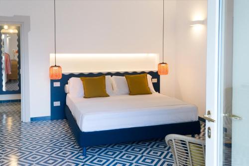 une chambre avec un grand lit avec des oreillers jaunes dans l'établissement o' mar - Amalfi Coast Suite, à Praiano