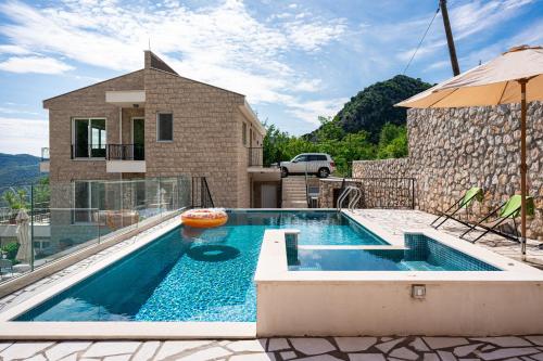 a swimming pool in front of a house at Ventus Rosa Villa in Budva
