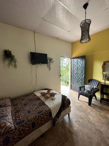 a bedroom with a bed and a tv and a chair at Villa Castillo de Ensueño in Concepción de Ataco