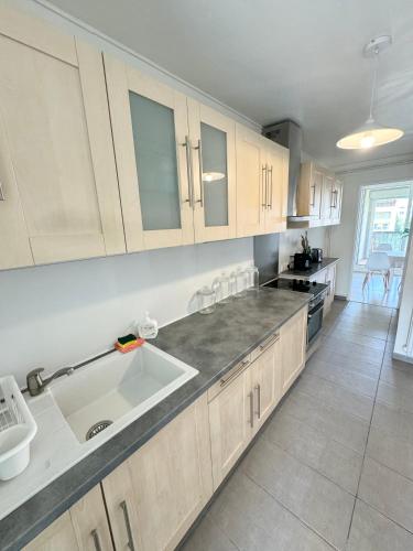 une cuisine avec des armoires blanches et un évier dans l'établissement Appartement T3,T4, à Aubagne