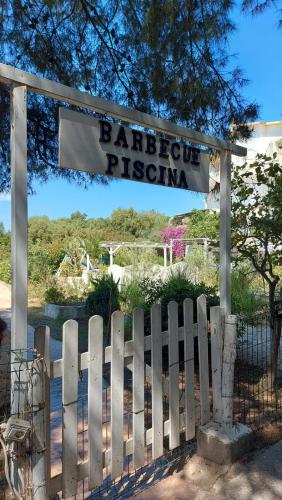 a white fence with a sign that reads barrettipop pizza at Villa Agnese in Badesi