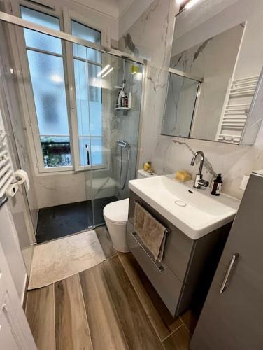 une salle de bain avec un lavabo et des toilettes et une fenêtre dans l'établissement Au coeur du marché Poncelet et à 2 pas de l'Arc de Triomphe - appartement 6 personnes et 1 bébé, sdb, 2 WC, à Paris