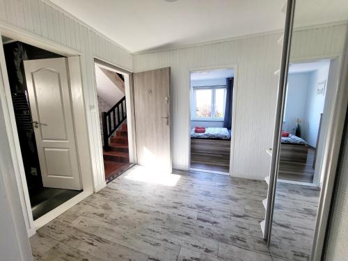 korytarzem z białymi ścianami i schodami z lustrem w obiekcie Dom na Błękitnej w Karwieńskim Błocie