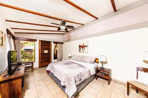 a bedroom with a bed and a flat screen tv at Xalli Beach Hotel in Altagracia