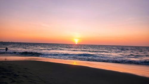 a person walking on the beach at sunset at Kites Mancora in Máncora