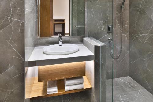 a bathroom with a sink and a shower at Le Meridien Hyderabad in Hyderabad