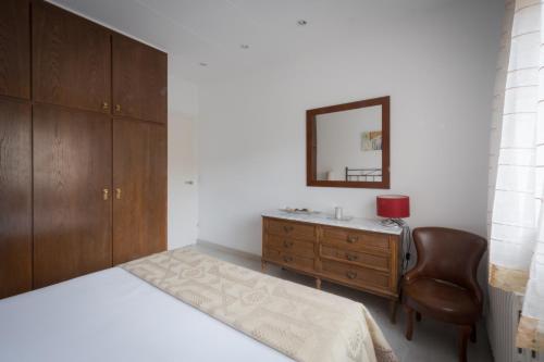 una camera con letto, cassettiera e specchio di El Solell de l'àvia a Olot