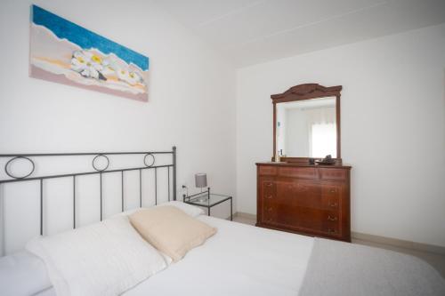 una camera con letto, cassettiera e specchio di El Solell de l'àvia a Olot