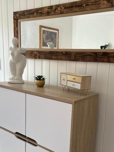 une étagère avec une statue et un miroir sur un mur dans l'établissement Le hameau de bannes deuxième maison, à Morlhon-le-Haut