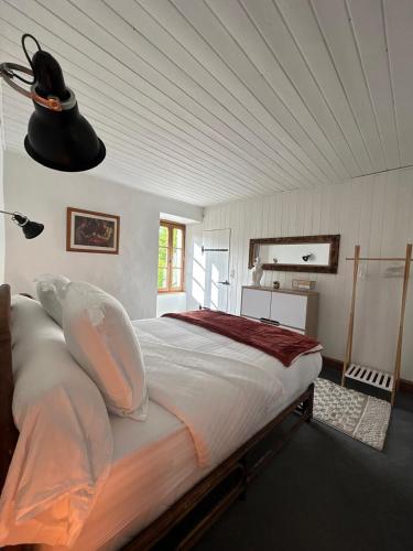 - une chambre avec un grand lit et une lampe noire dans l'établissement Le hameau de bannes deuxième maison, à Morlhon-le-Haut