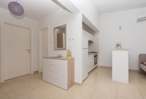 una cocina blanca con encimera en una habitación en Apartments Nina M en Baška Voda